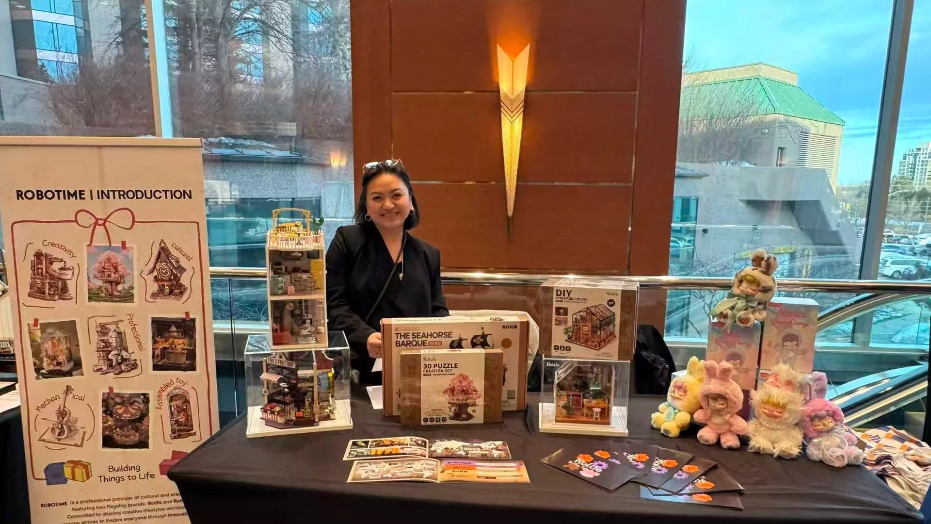 Miriam Reina Behind A Table with Promotional Materials and Products in An Indoor Setting