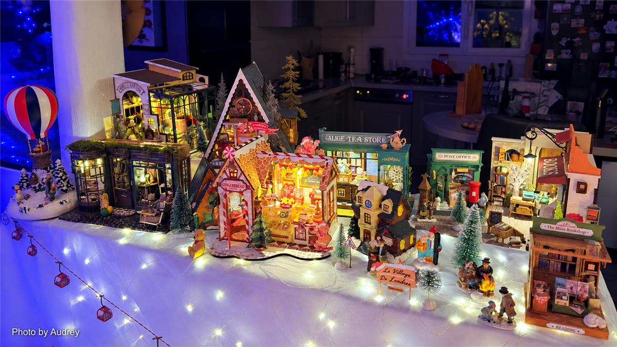 Audrey's illuminated Robotime Christmas village display with miniature houses, shops, trees, and winter decorations