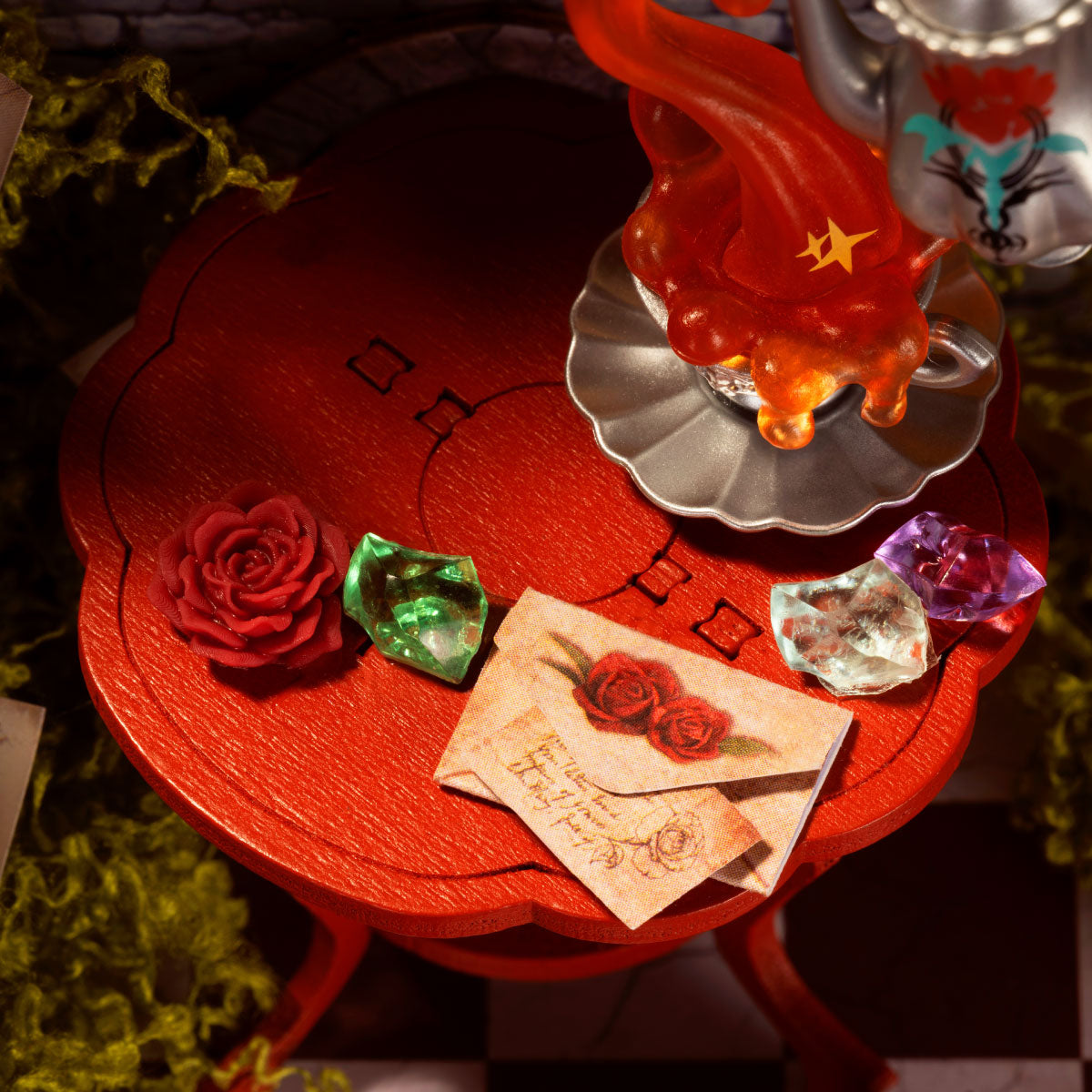 Rolife Rosa Salon DS055 table detail with red table, rose, colorful gemstones, envelope and floating teapot with orange smoke