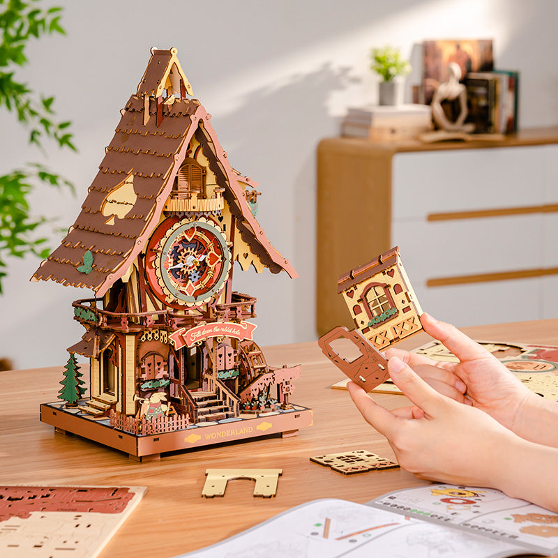 Wooden cuckoo clock model with hands assembling on a wooden table