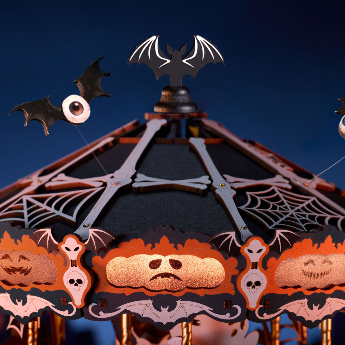 Rolife Phantom Waltz DIY Music Box AMS04 close-up of the carousel canopy with spider webs, skull trim, pumpkin panels, and one-eyed bats