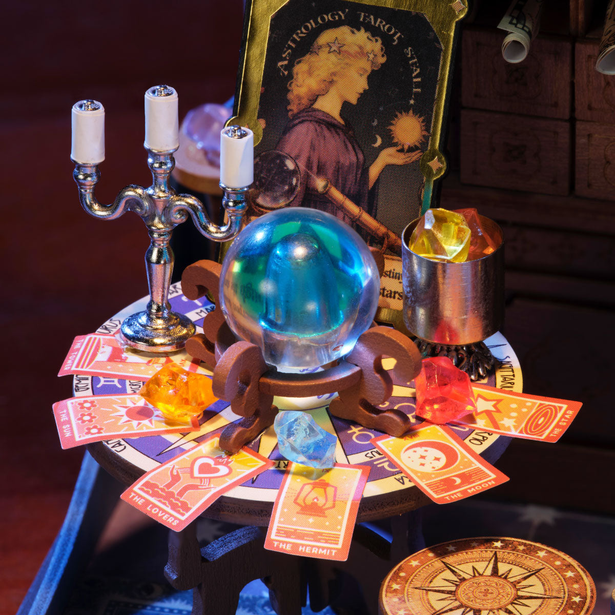 Rolife Astral Dome DS058 close-up of tarot reading table with blue crystal ball, colorful gemstones, candlestick and astrology tarot poster
