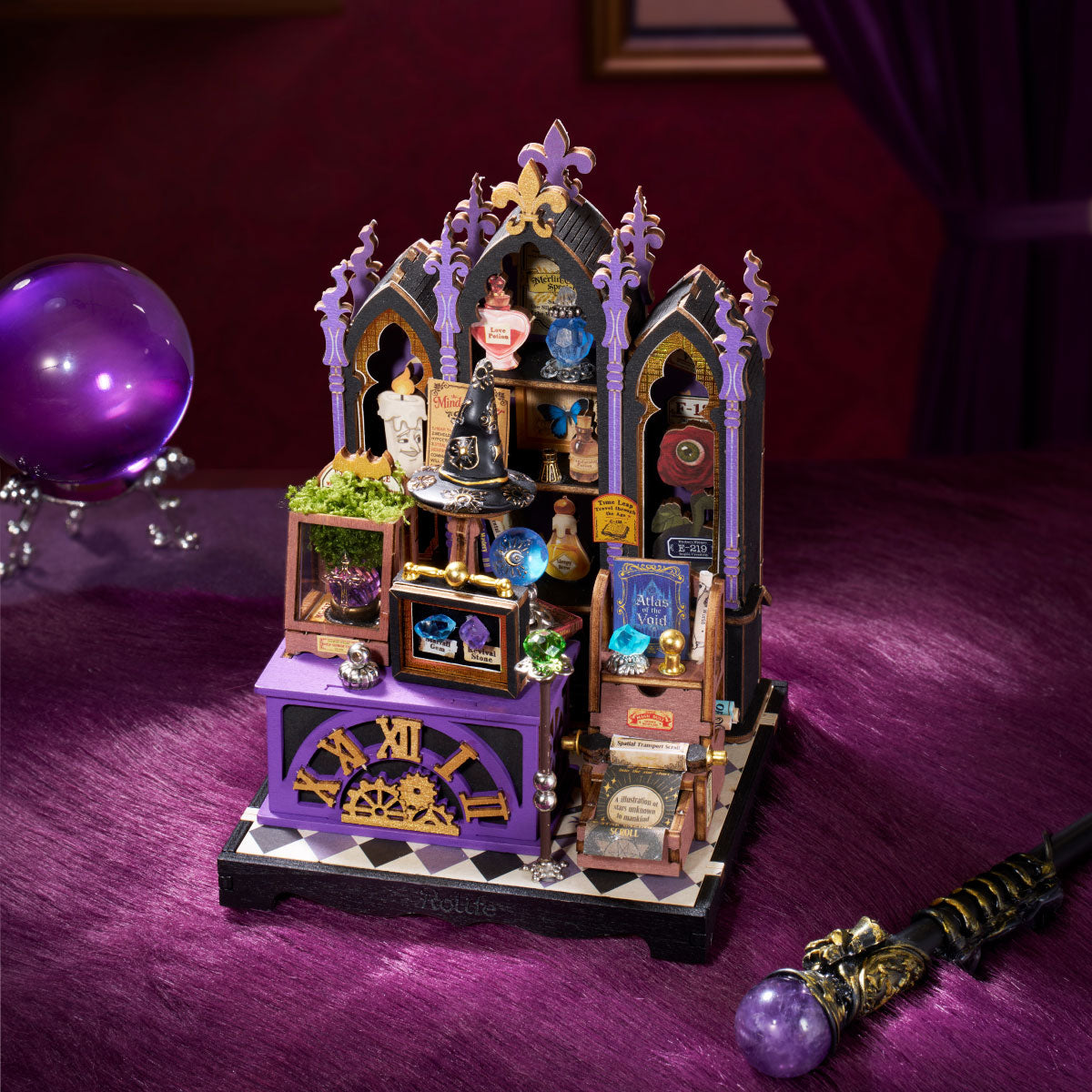 Rolife Curio Corner DS056 displayed in a moody room scene with crystal ball, magic wand, red curtain and glowing purple shop details