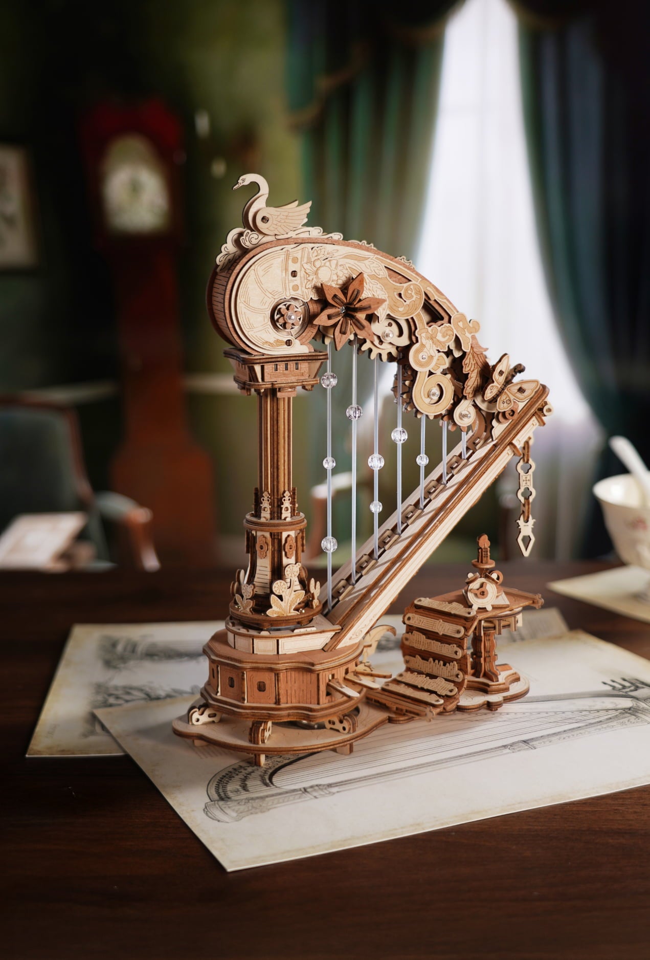 Detailed wooden harp model with carved gears and slender strings on a desk