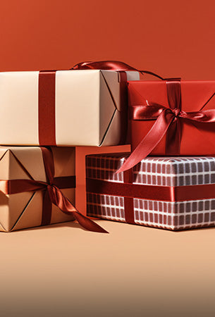 Four gift boxes with ribbons on a brown background