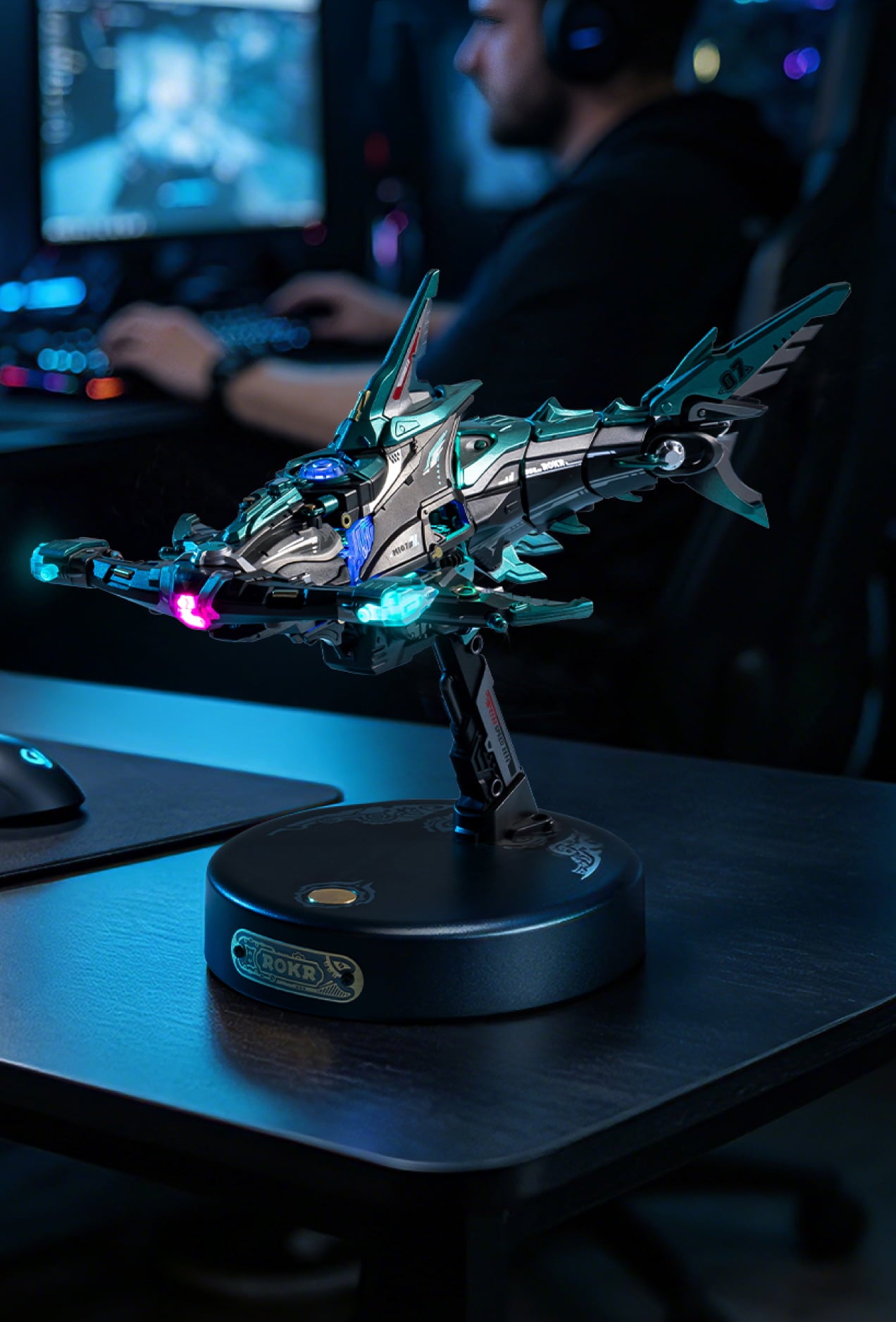 Futuristic mechanical creature model glowing blue and purple on a round display base