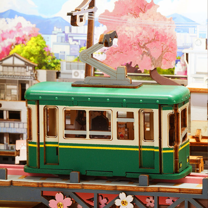 ROKR Strolling in the Sunshine klassieke groene Hiroshima-tram onder roze kersenbloesems